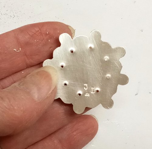 Judy Larson's CZ Explosion Necklace - , Holiday Designs, Cutting, Cutting Tool, Cutters, Filing, Finishing, How To Punch Holes, Hole Punching, Punch A Hole, Tumbling, Tumble, Tumbling Jewelry, Butane Torch, Soldering, Solder, Design, Drilling, Drill, Drilling pushed a sharp edge to the back of the backplate.